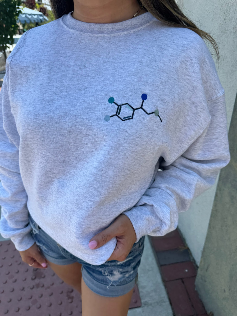 Model wearing Ladyspinedoc x Dr. Beachgem Code Cart Crewneck Sweatshirt - Gray Shirt with Embroidered Epinephrine (Adrenaline) Molecule Design