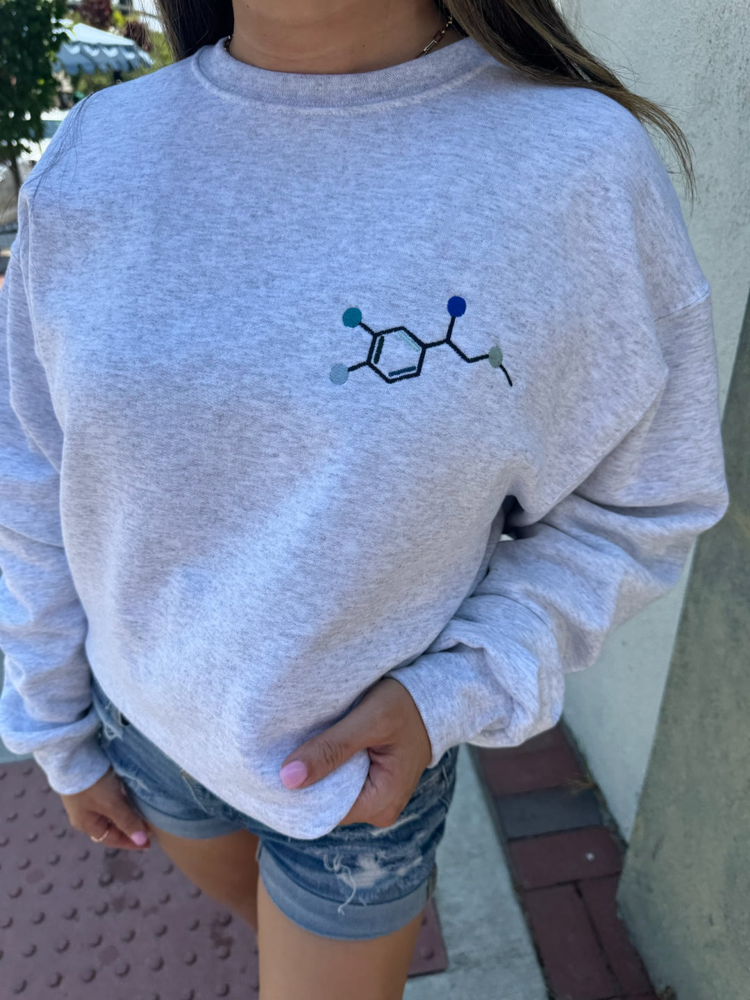 Model wearing Ladyspinedoc x Dr. Beachgem Code Cart Crewneck Sweatshirt - Gray Shirt with Embroidered Epinephrine (Adrenaline) Molecule Design