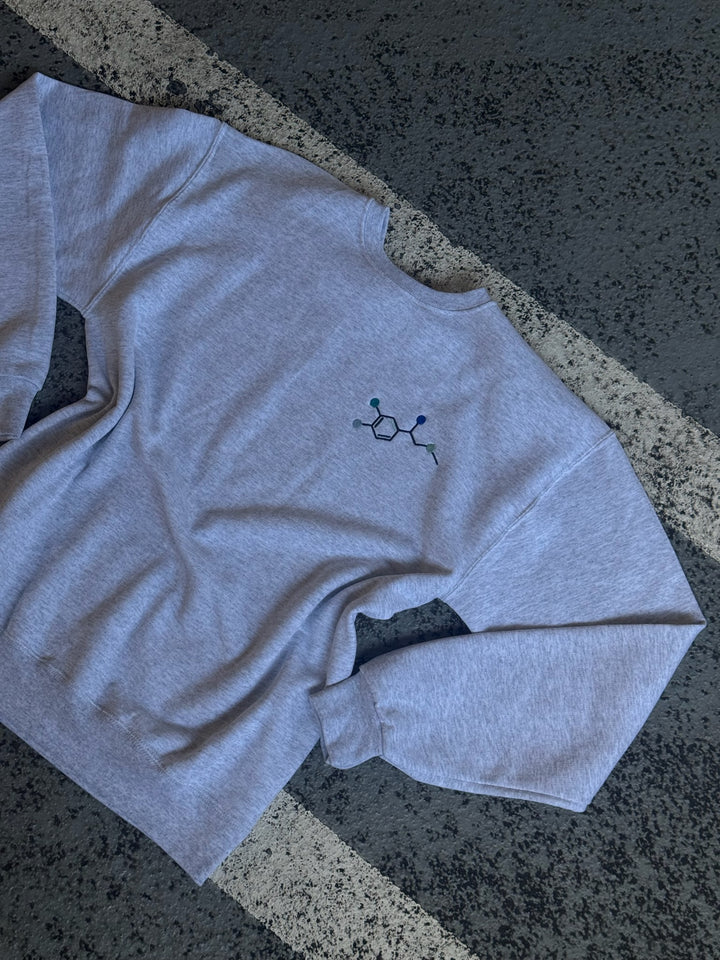 Flat lay of Ladyspinedoc x Dr. Beachgem Code Cart Crewneck Sweatshirt - Gray Shirt with Embroidered Epinephrine (Adrenaline) Molecule Design