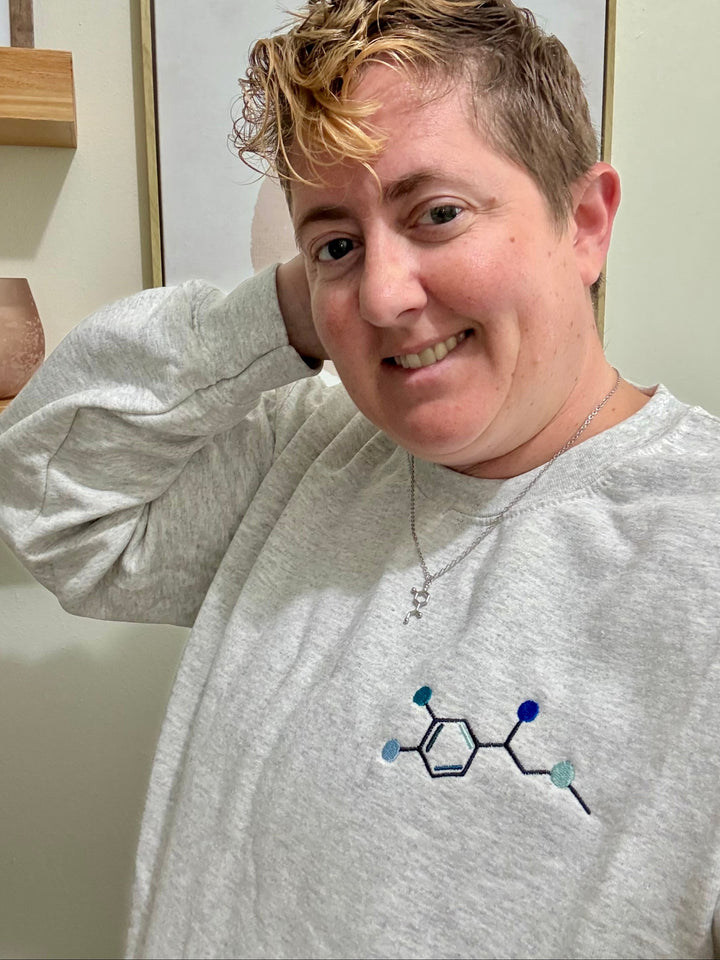 Side view of Dr Beachgem wearing Ladyspinedoc x Dr. Beachgem Code Cart Crewneck Sweatshirt - Gray Shirt with Embroidered Epinephrine (Adrenaline) Molecule Design and Noradrenaline necklace. 