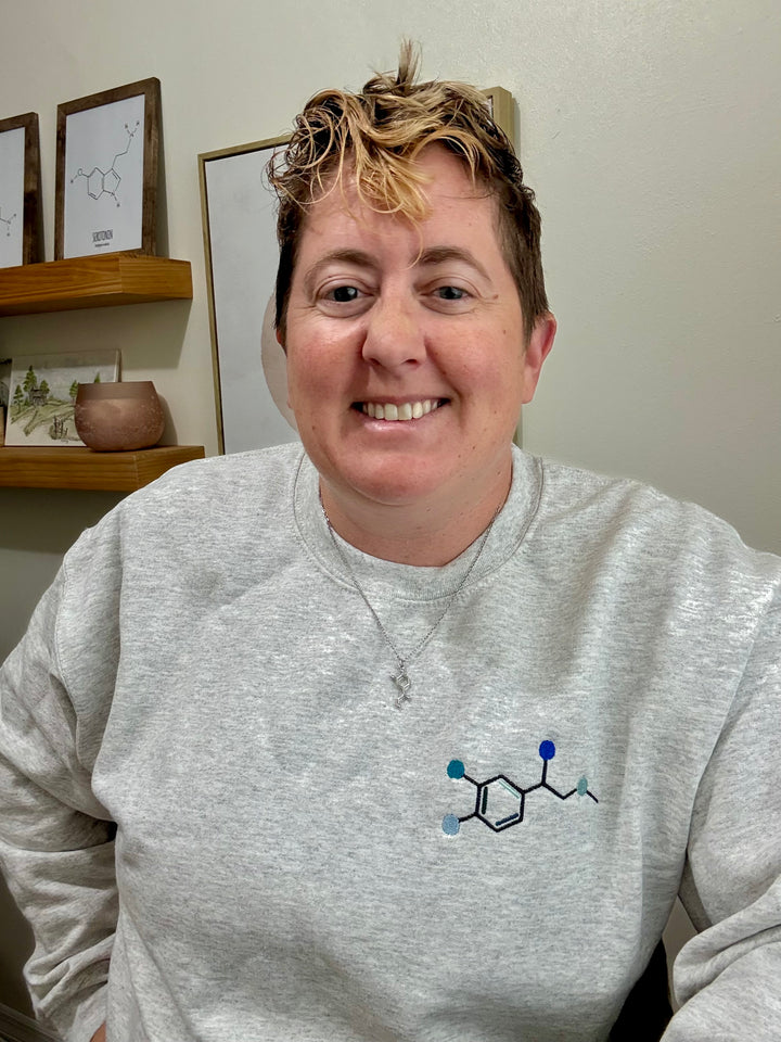 Smiling Dr Beachgem wearing Ladyspinedoc x Dr. Beachgem Code Cart Crewneck Sweatshirt - Gray Shirt with Embroidered Epinephrine (Adrenaline) Molecule Design and Noradrenaline necklace. 