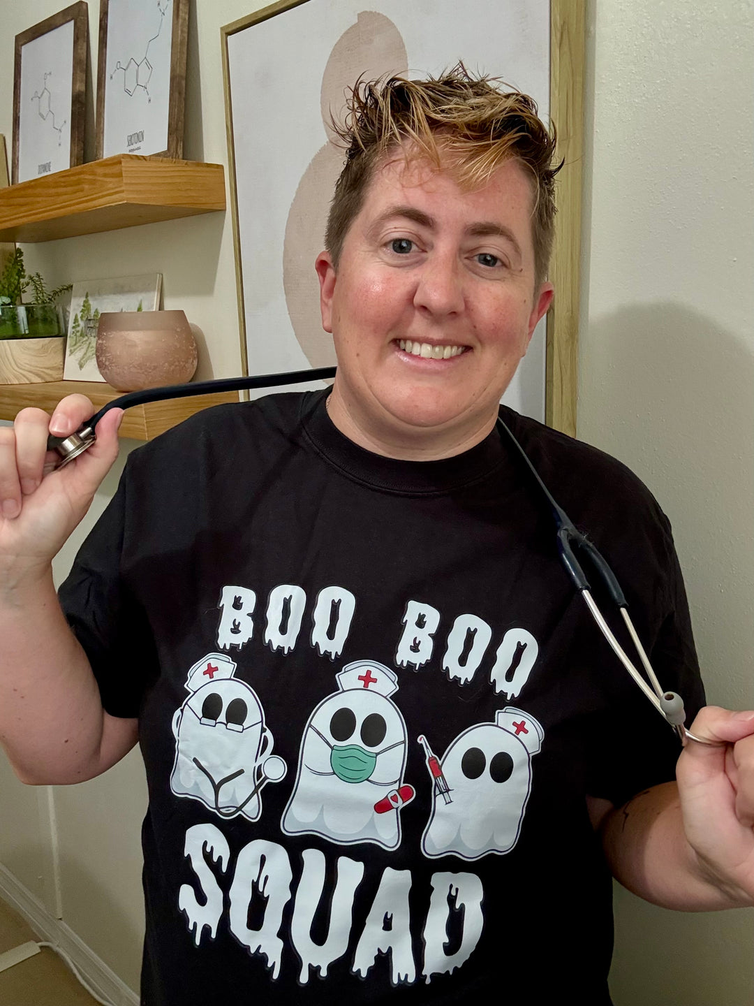 Dr. Beachgem holding a stethoscope and wearing the black Boo Boo Squad Tee Shirt with ghost nurses 