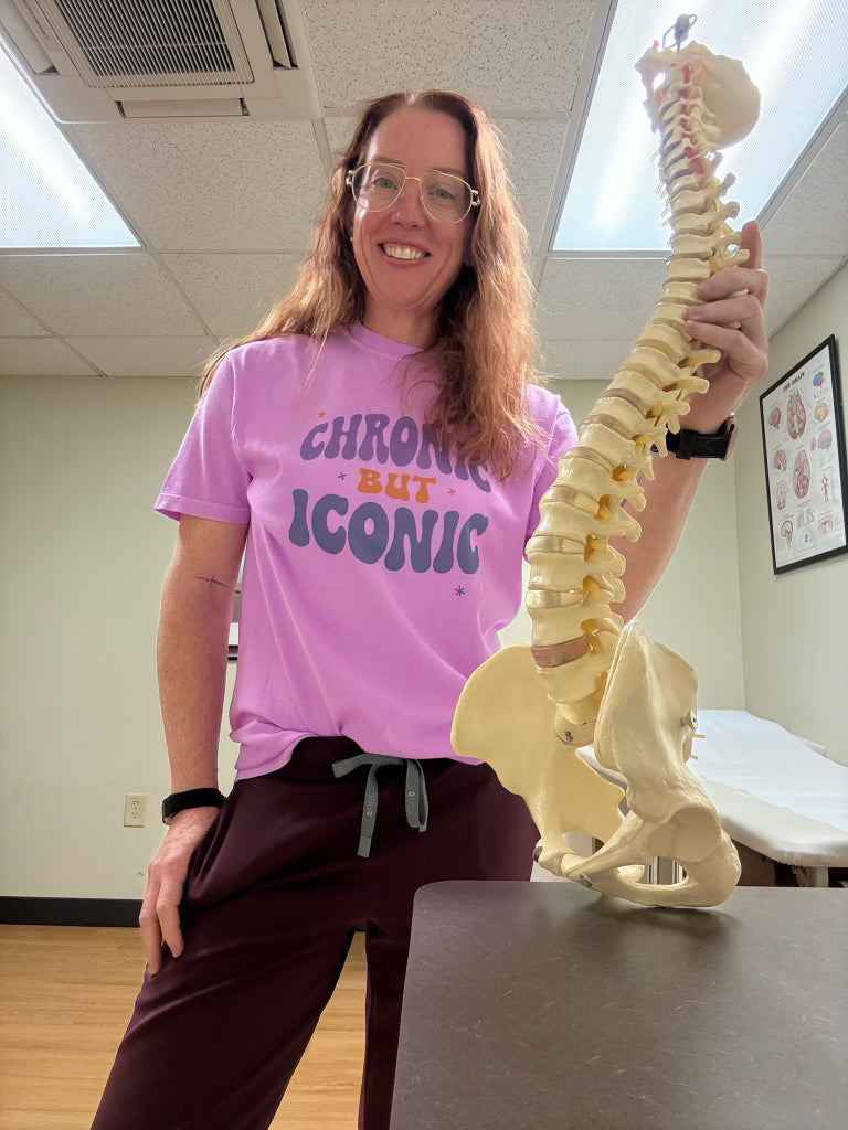 Person holding a model of a spine in an indoor setting