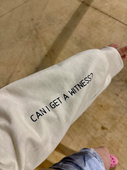 Sand-colored sweatshirt sleeve with black text that reads “CAN I GET A WITNESS?” for nurse humor
