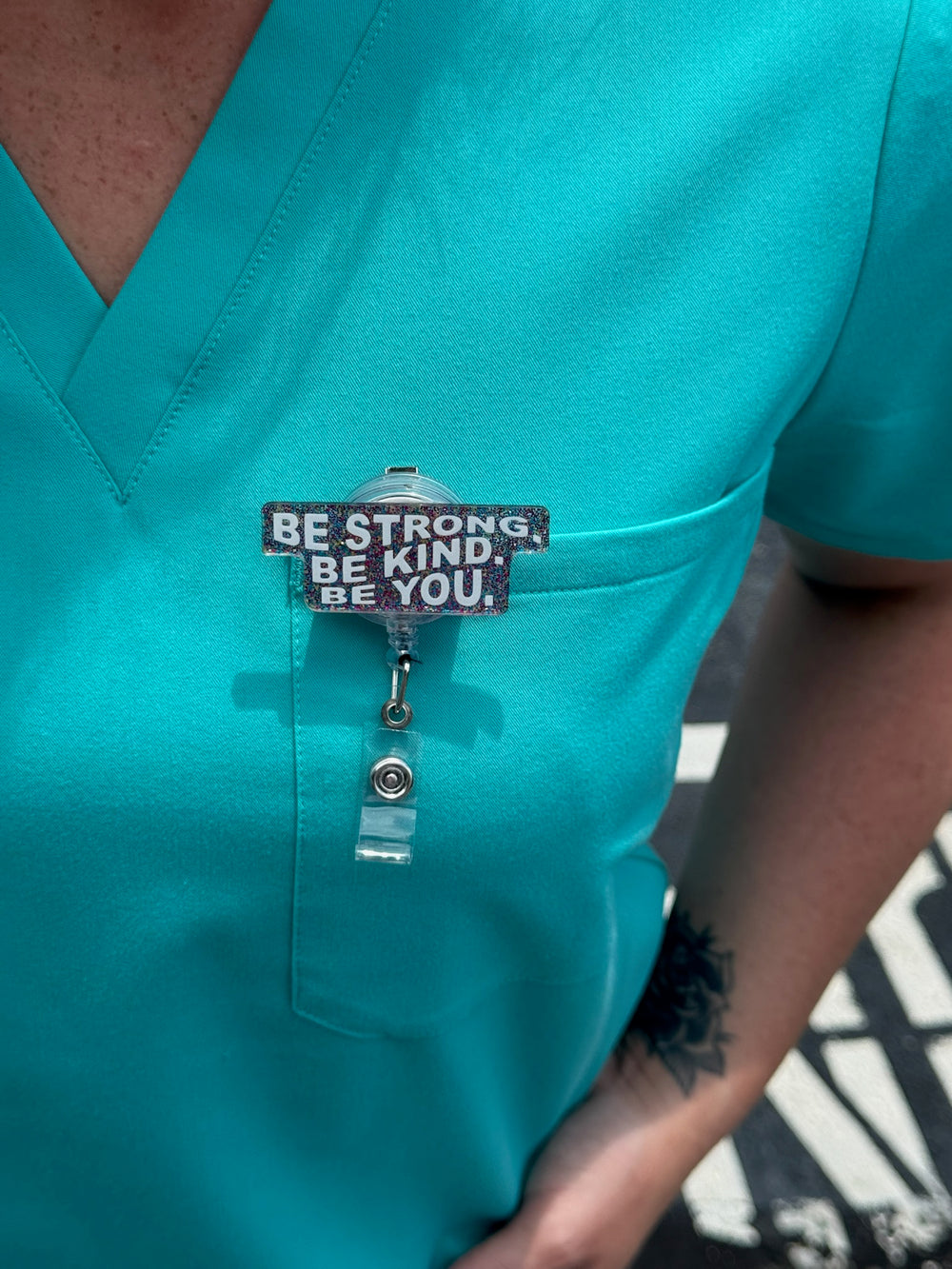 Be You Glitter Badge Reel - Retractable with Alligator Clip cliped on front pocket of aqua scrubs