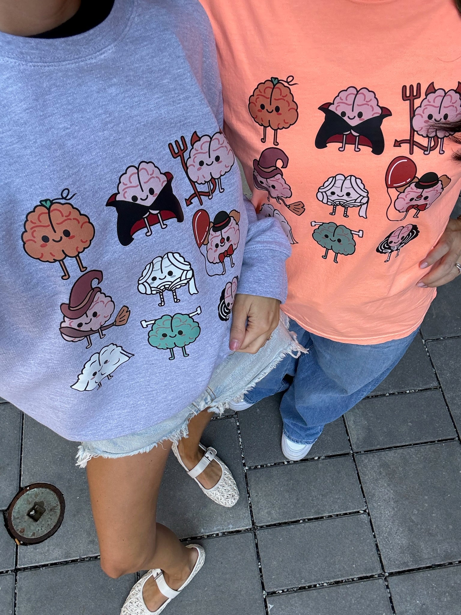 Models wearing Halloween Brains Orange Tee Shirt and Gray Sweatshirt with Cartoon Brain Characters: Pumpkin, Ghost, Witch, Vampire, Mummy & More