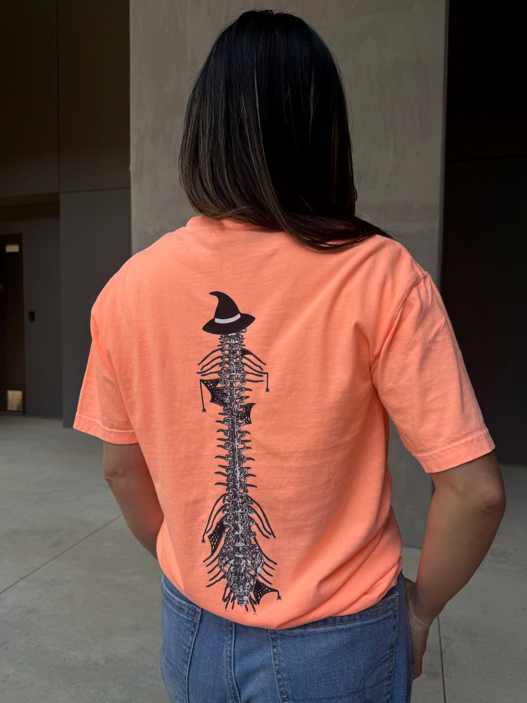 Model showing back of Halloween Spooky Spine - Orange Short Sleeve Tee Shirt