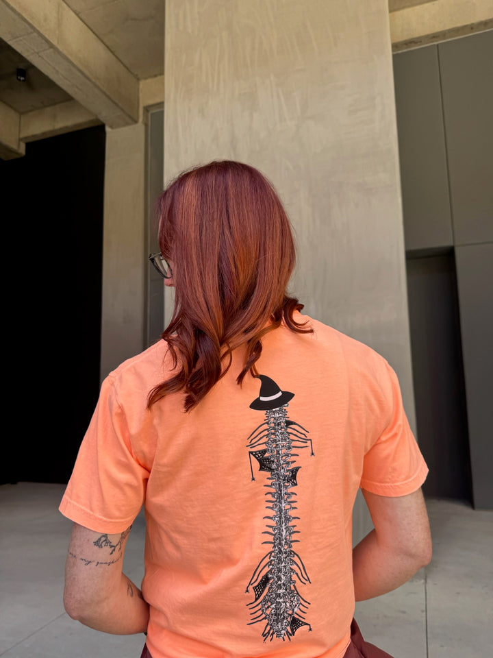 Ladyspinedoc wearing Halloween Spooky Spine - Orange Short Sleeve Tee Shirt and showing off the back spine design