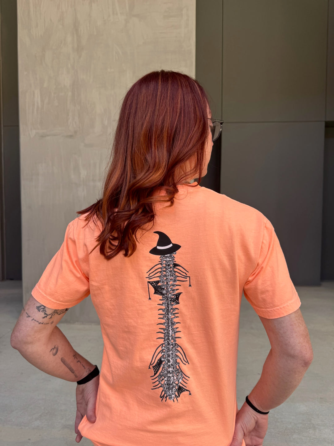 Ladyspinedoc wearing Halloween Spooky Spine - Orange Short Sleeve Tee Shirt and showing off the back spinal design