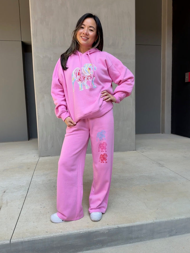 Model showing off the front of the Chan Art Collab: Game Day Set - Pink Hoodie & Sweatpants with colorful bulldogs