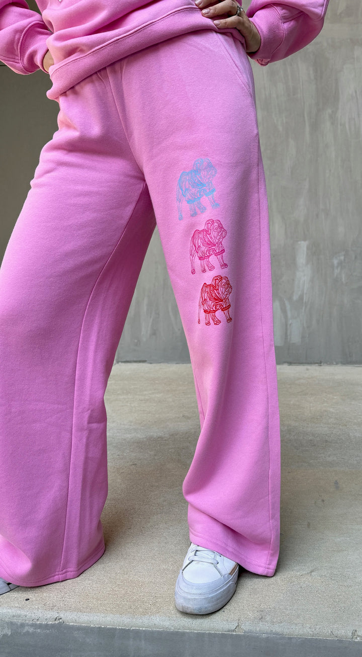 Model wearing Chan Art Collab: Game Day Set pink sweatpants with three colorful bulldogs