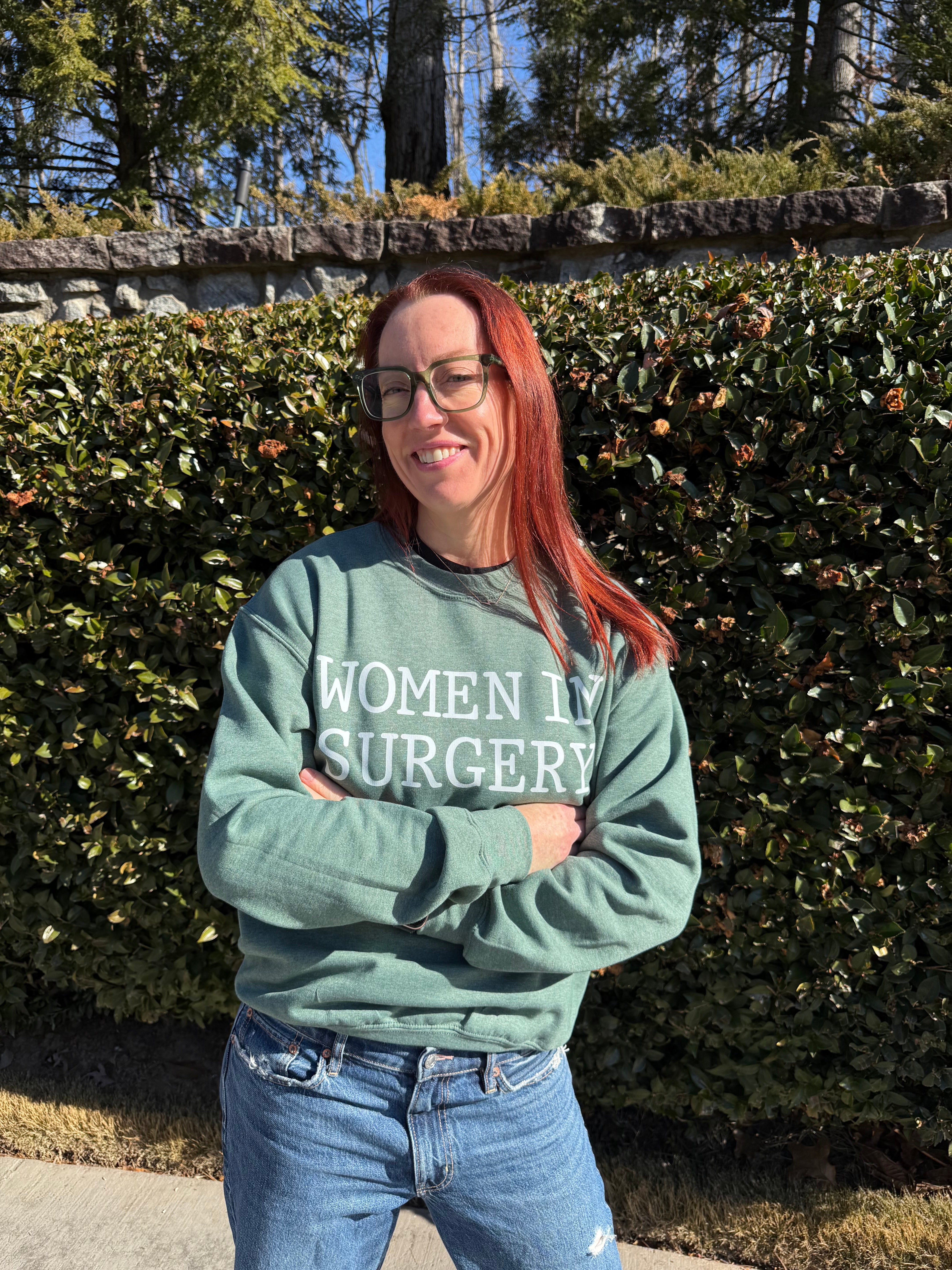 Dr Betsy Grunch (Ladyspinedoc) wearing the green Women In Surgery crewneck sweatshirt